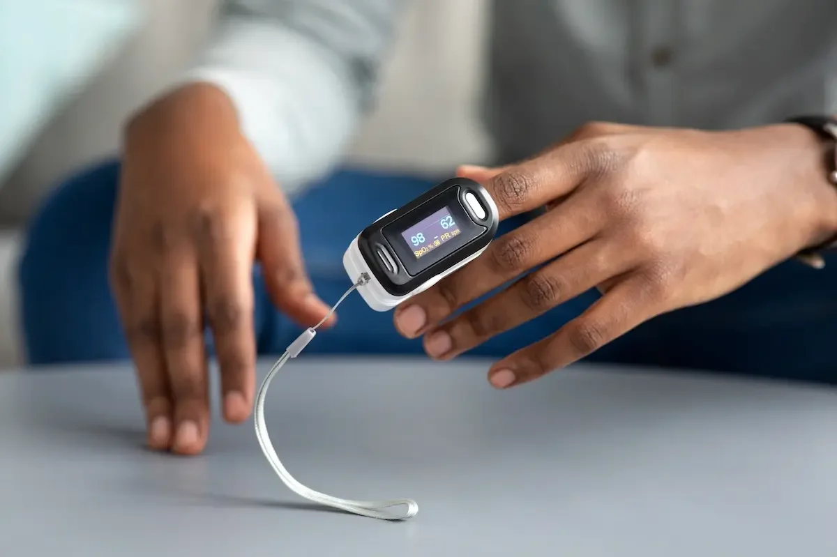 Pulsoximetrie - Bestimmung der Sauerstolffkonzentration Ein Handgelenks-Oximeter wird an einem Finger angesteckt. Die Sauerstoffkonzentration im Blut wird bestimmt.