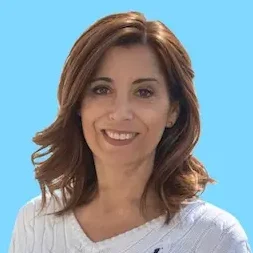 Dr. Mehtap Prandstetter Frau mit langen, lockigen Haaren und freundlichem Lächeln vor weißem Hintergrund.