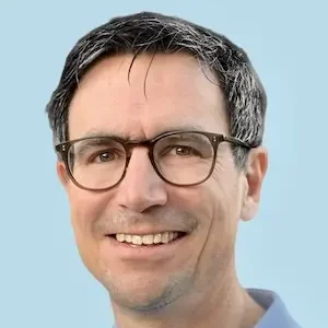 Kinderkardiologe Christoph Prandstetter Porträt eines lächelnden Mannes mit Brille und grau-schwarzen Haaren.